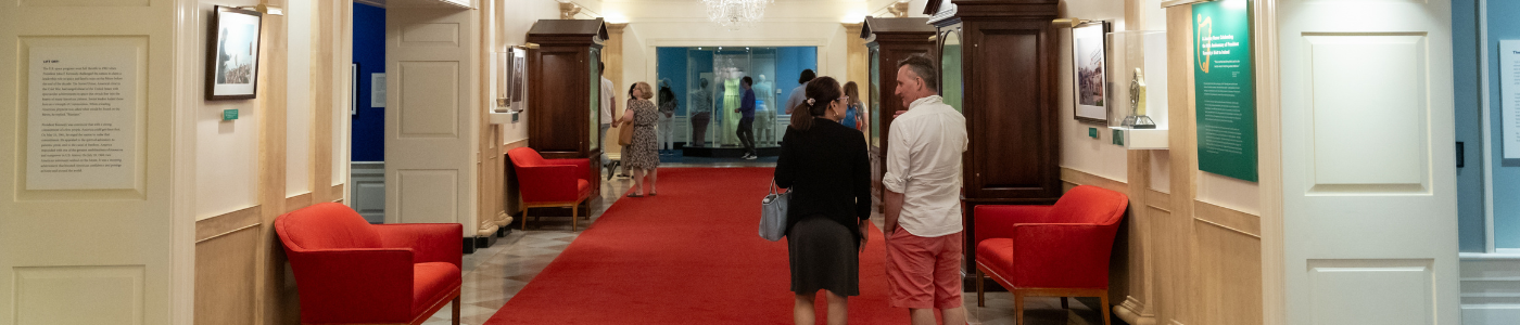 Two people walk through the White House Corridor exhibit